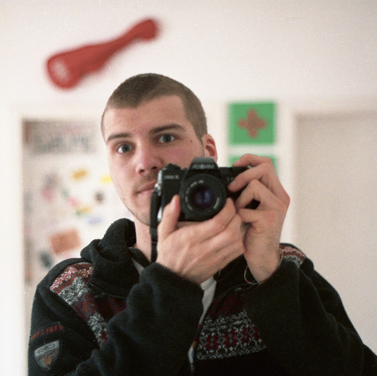 Ich mit einer analogen Spiegelreflexkamera vor dem Spiegel.